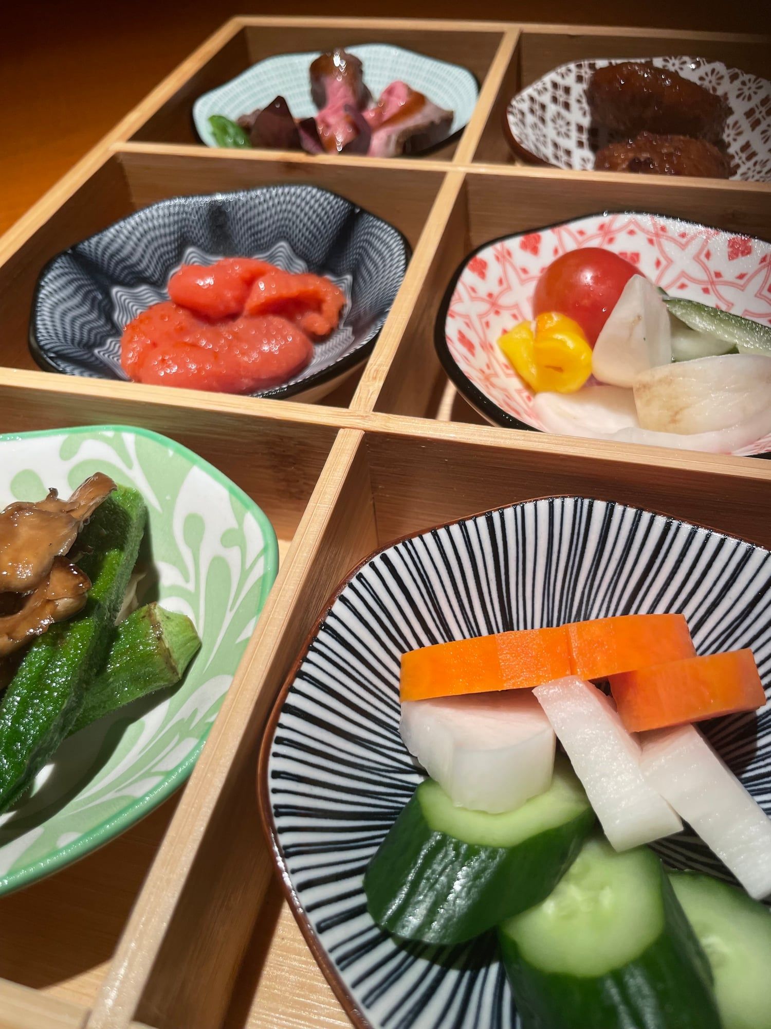 木枠の箱に小鉢で並ぶおばんざい