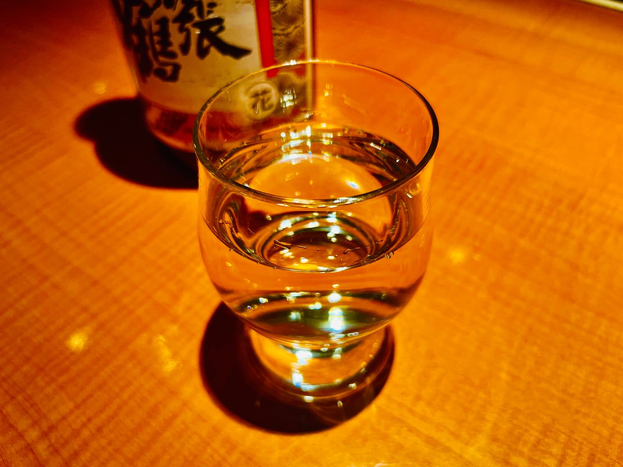 酒瓶を背にグラスに注がれた酒